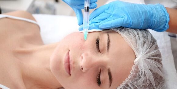Eine Kosmetikerin führt eine Gesichtshautverjüngung mit Plasma durch. 